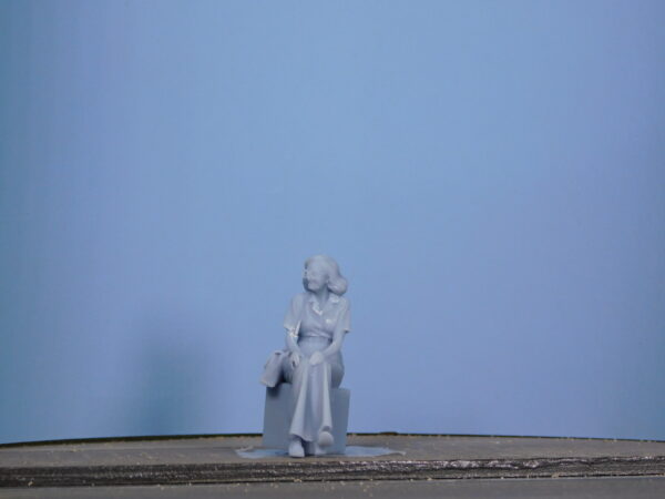 Personaggio femminile seduto viaggiatrice in scala 0